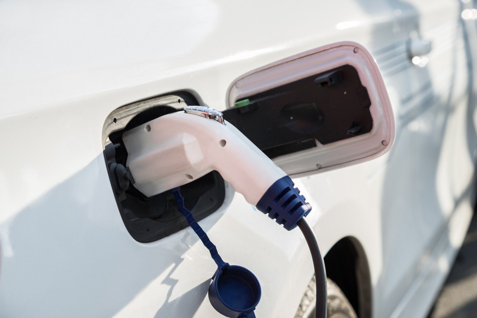 An electric car is being charged at a charging station.