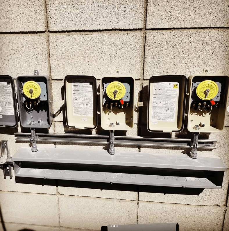 A row of electrical boxes on a brick wall