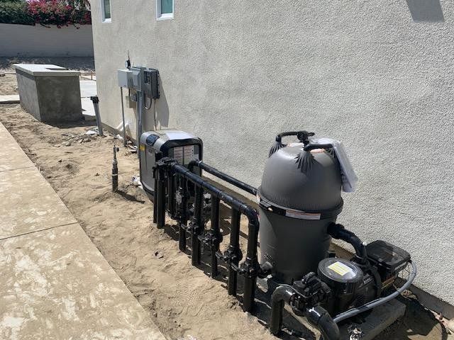 A swimming pool filter is sitting on the side of a house.