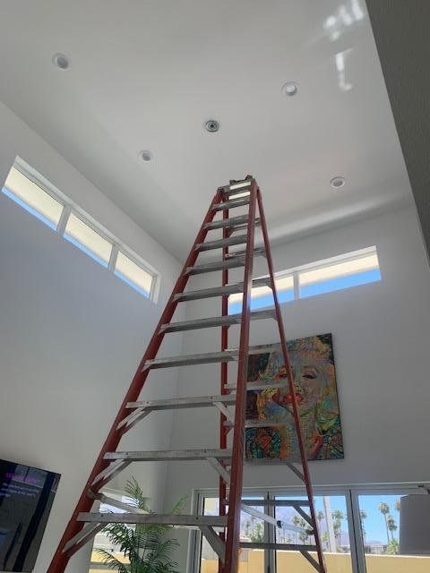 A ladder in a room with a painting on the wall