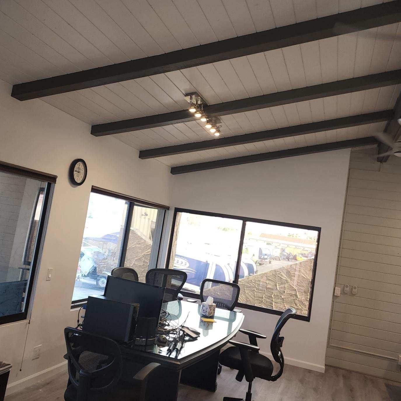 A conference room with a table and chairs and a clock on the wall.