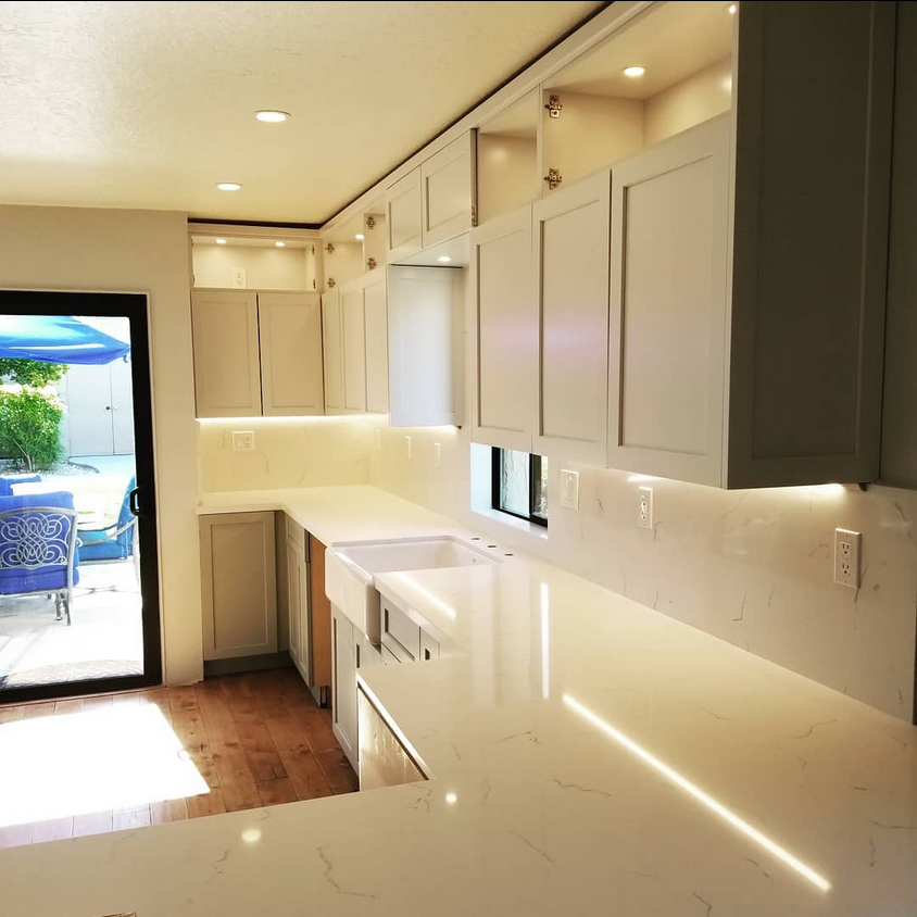 A kitchen with white cabinets and white counter tops