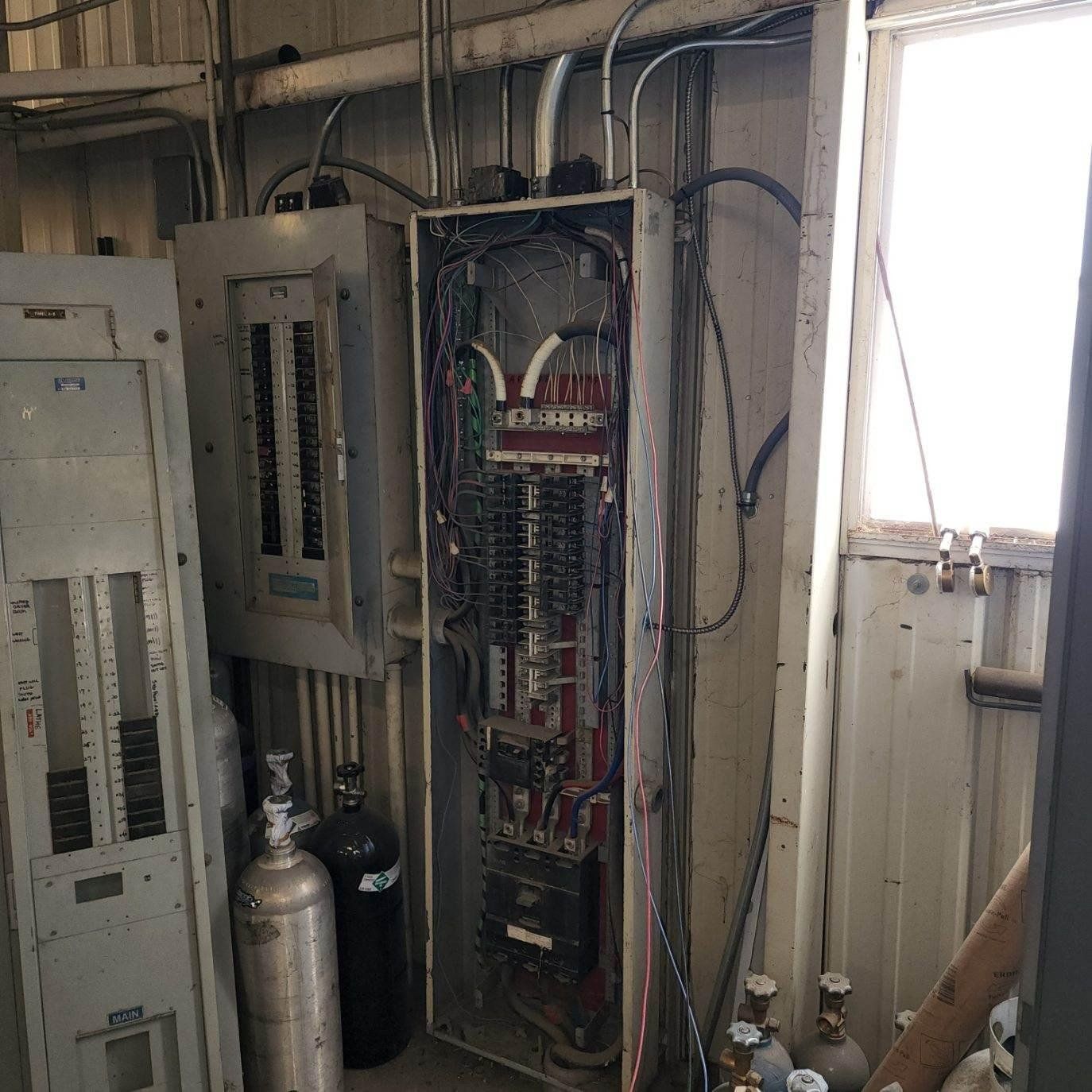 A room with a lot of electrical equipment and a window