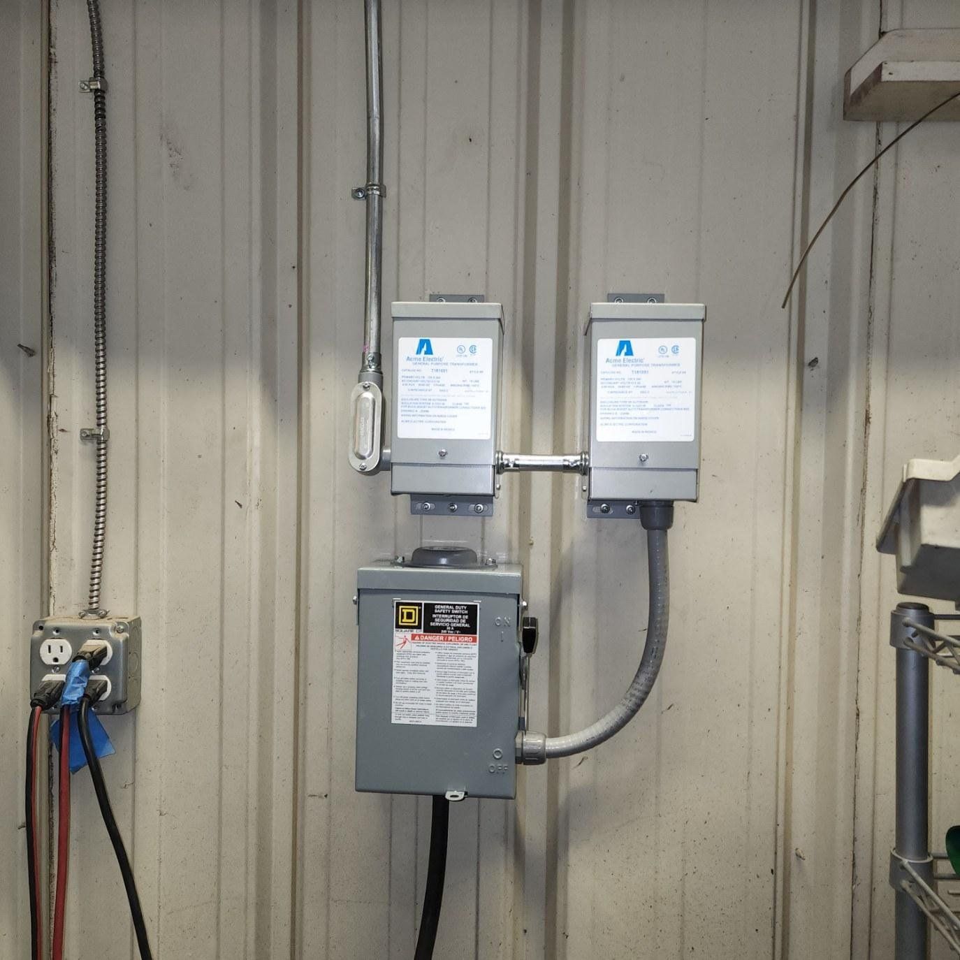 A couple of electrical boxes hanging on a wall