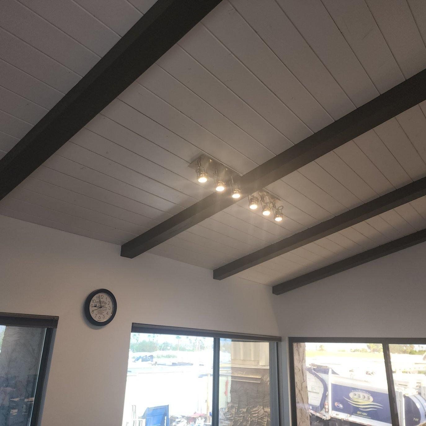 A room with a clock on the wall and a ceiling