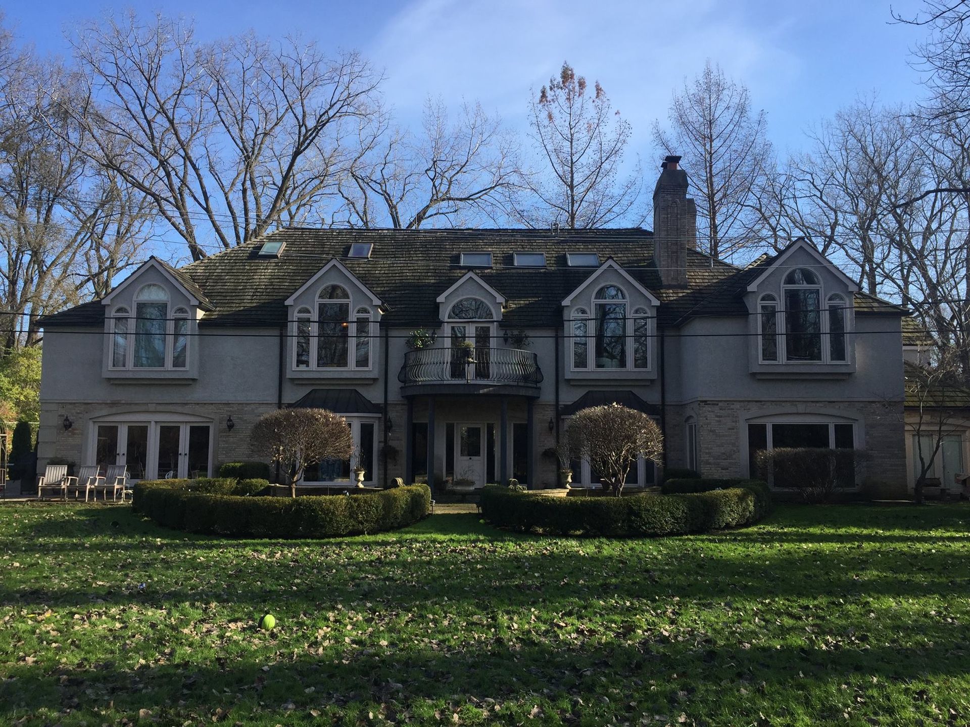 A large house with a lot of windows and trees in the background