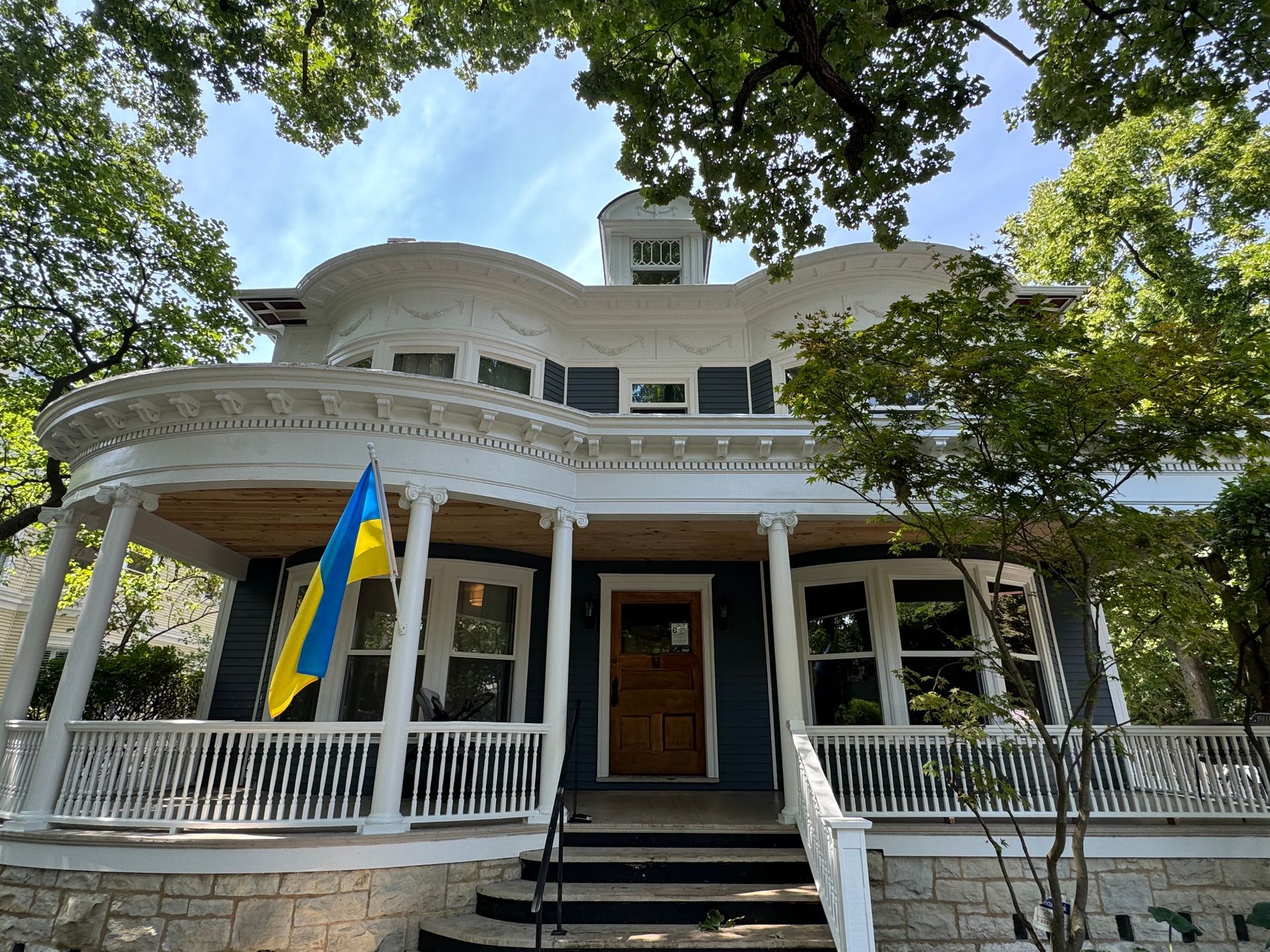 A Victorian house with a Ukrainian flag hanging from the porch.