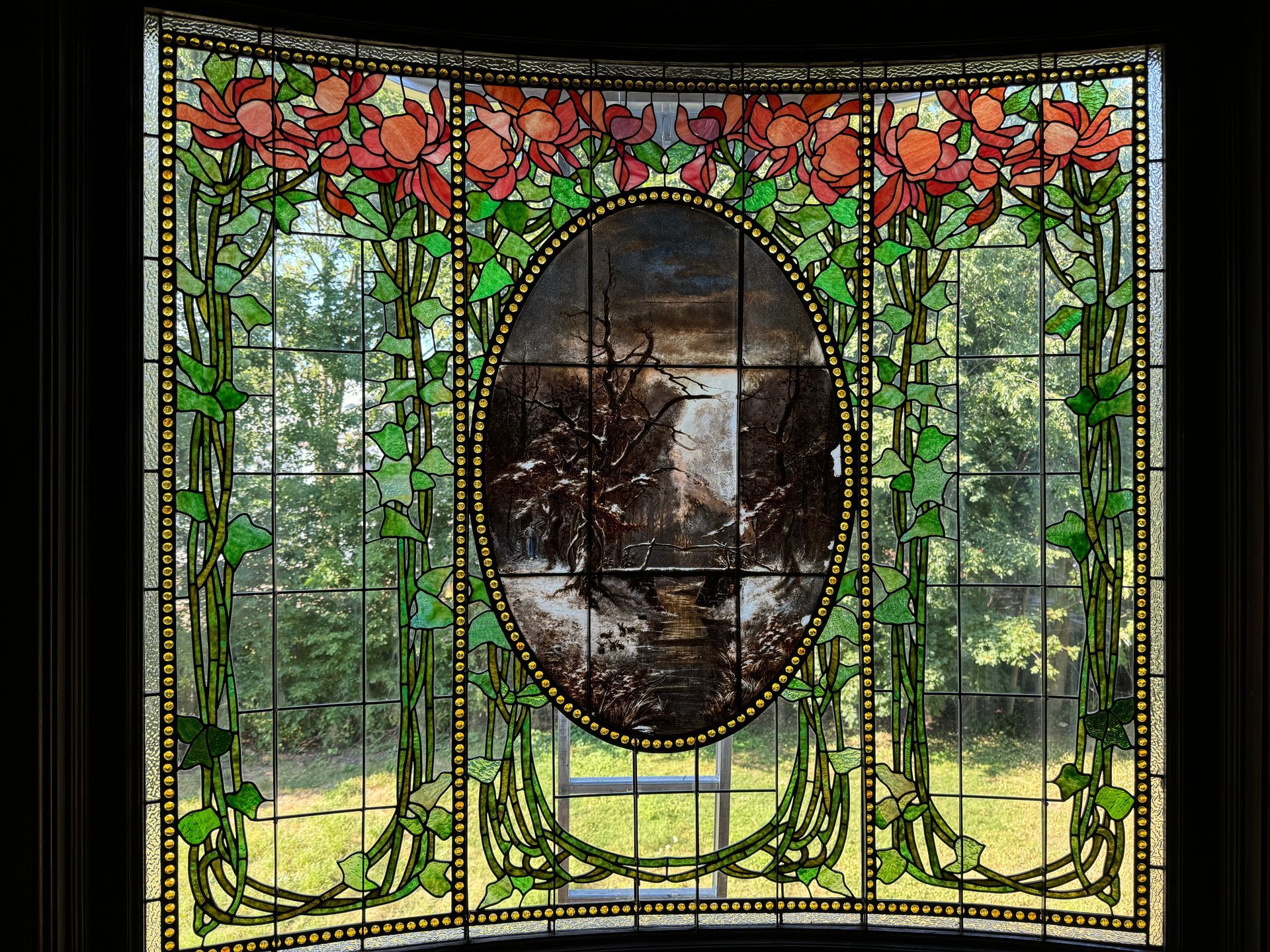 A stained glass window with a picture of a waterfall in the middle.