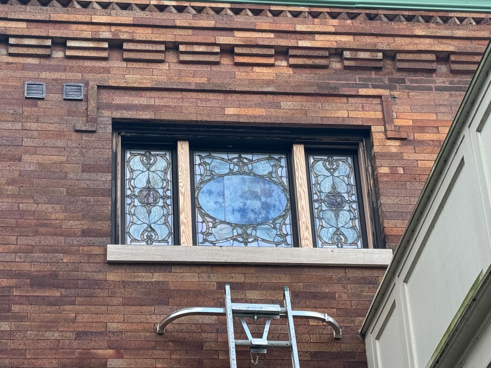 A ladder is attached to the side of a brick building