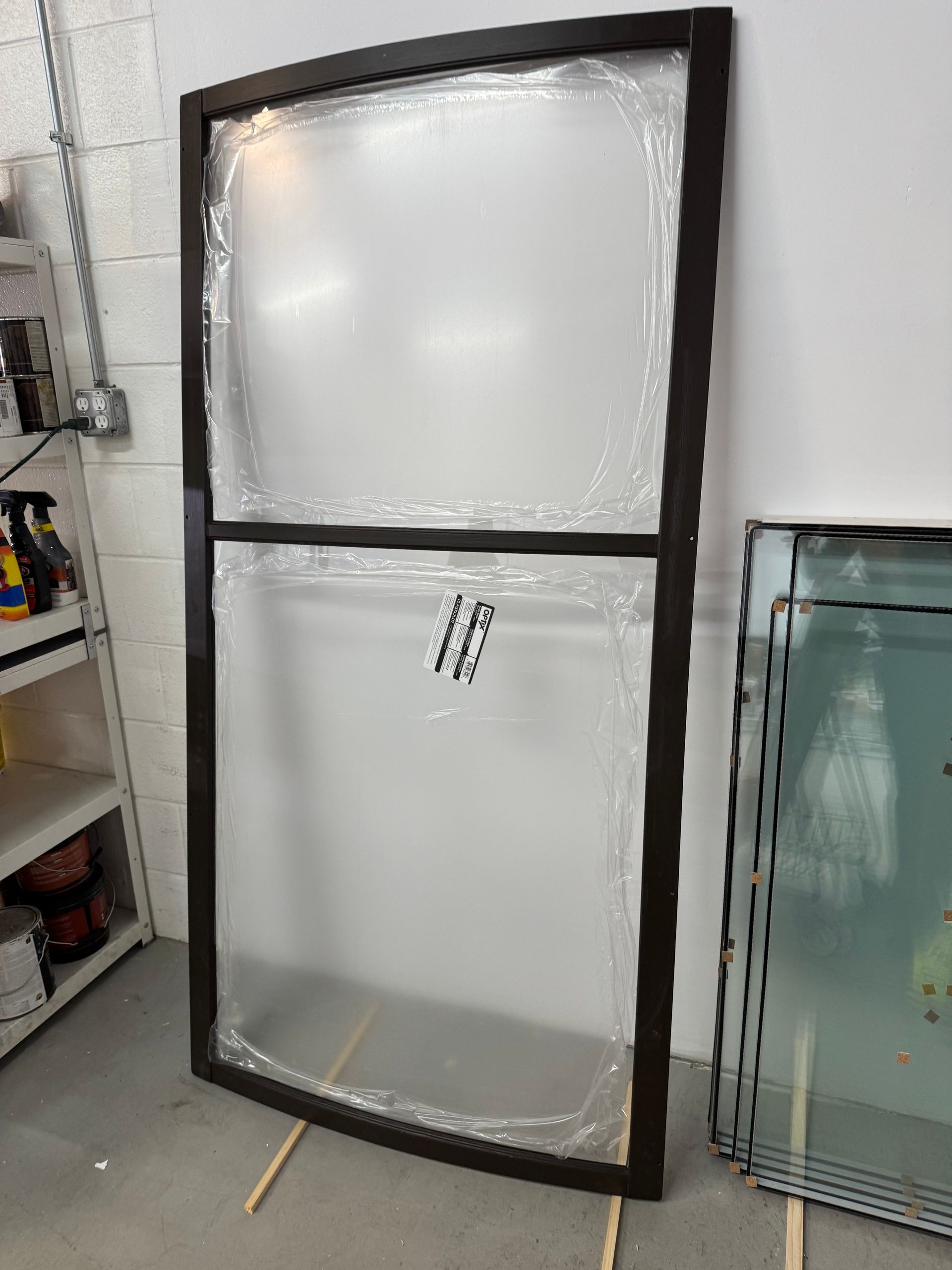 A large glass door is sitting on the floor in a room.