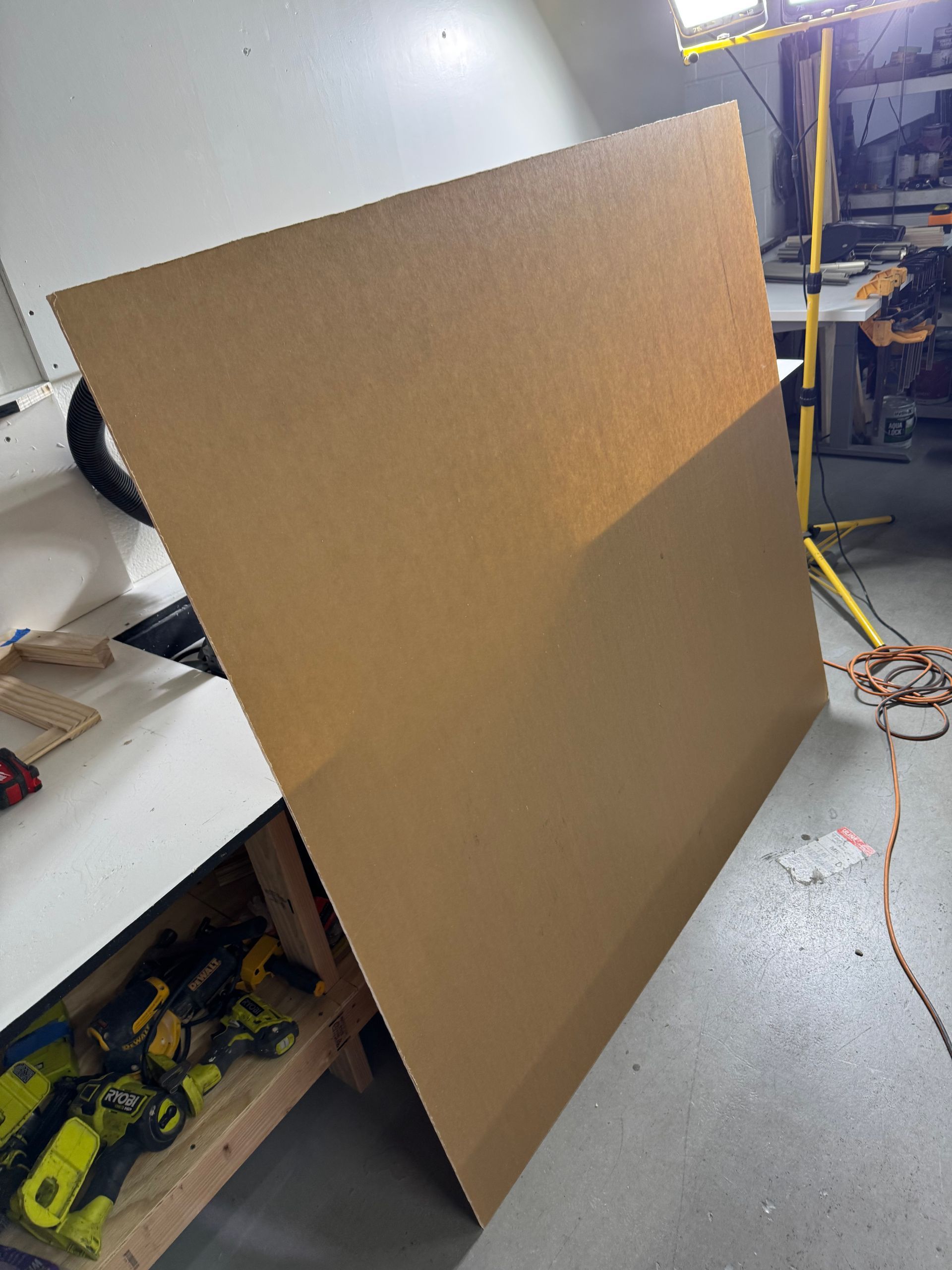 A large piece of cardboard is sitting on the floor in a workshop.