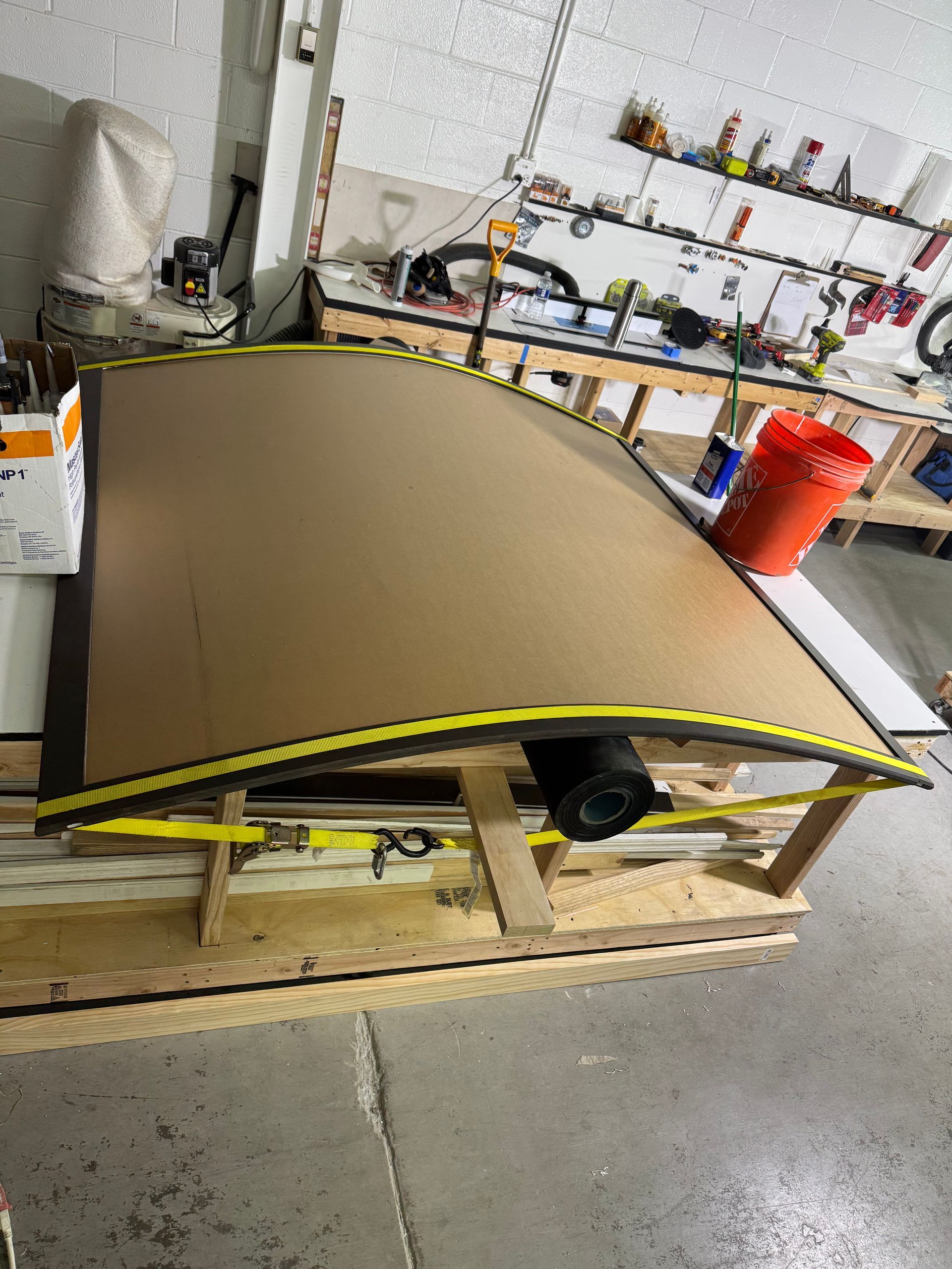 A large piece of cardboard is sitting on top of a wooden table in a workshop.