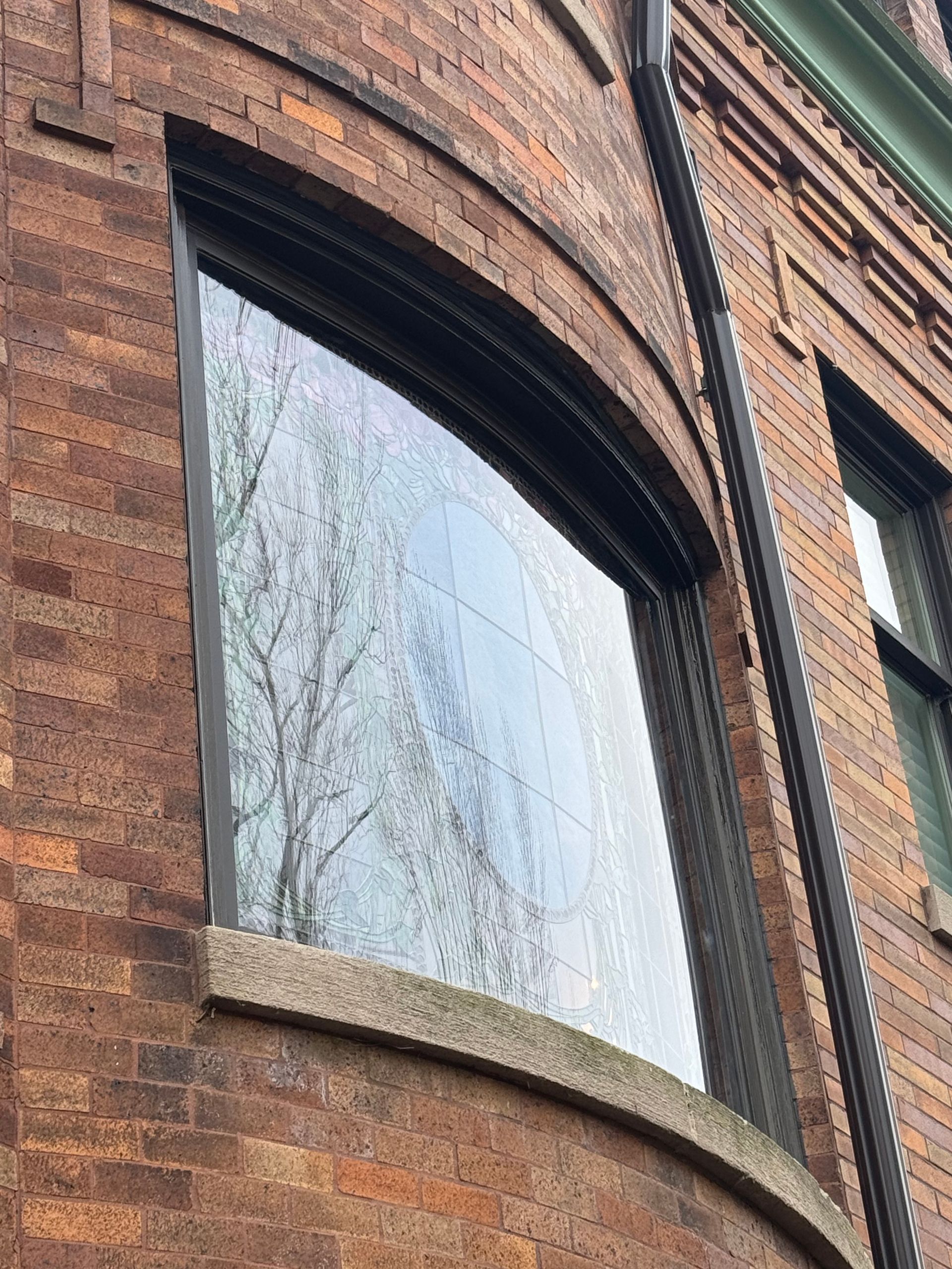 A brick building with a curved window on the side of it.