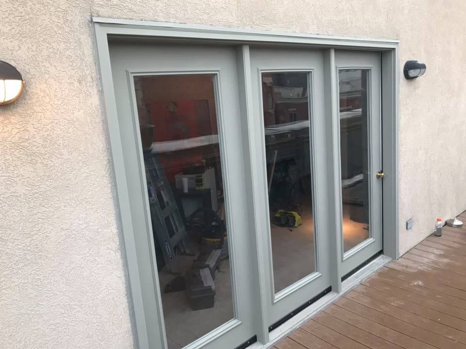 A sliding glass door is sitting on top of a wooden deck.