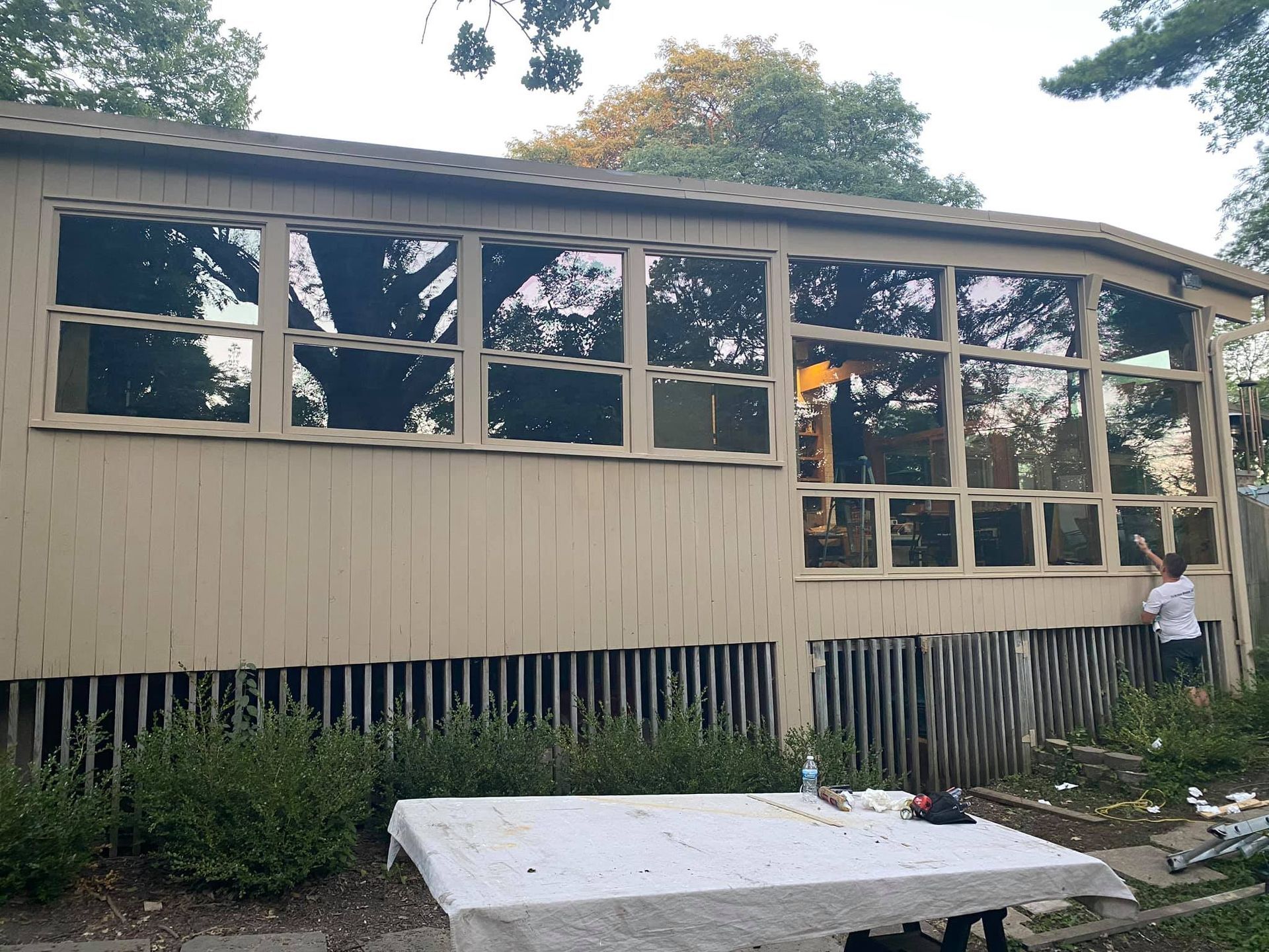 A house with a lot of windows and a table in front of it