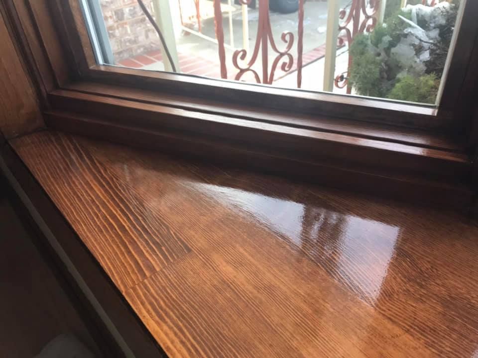A wooden window sill with a view of a balcony.