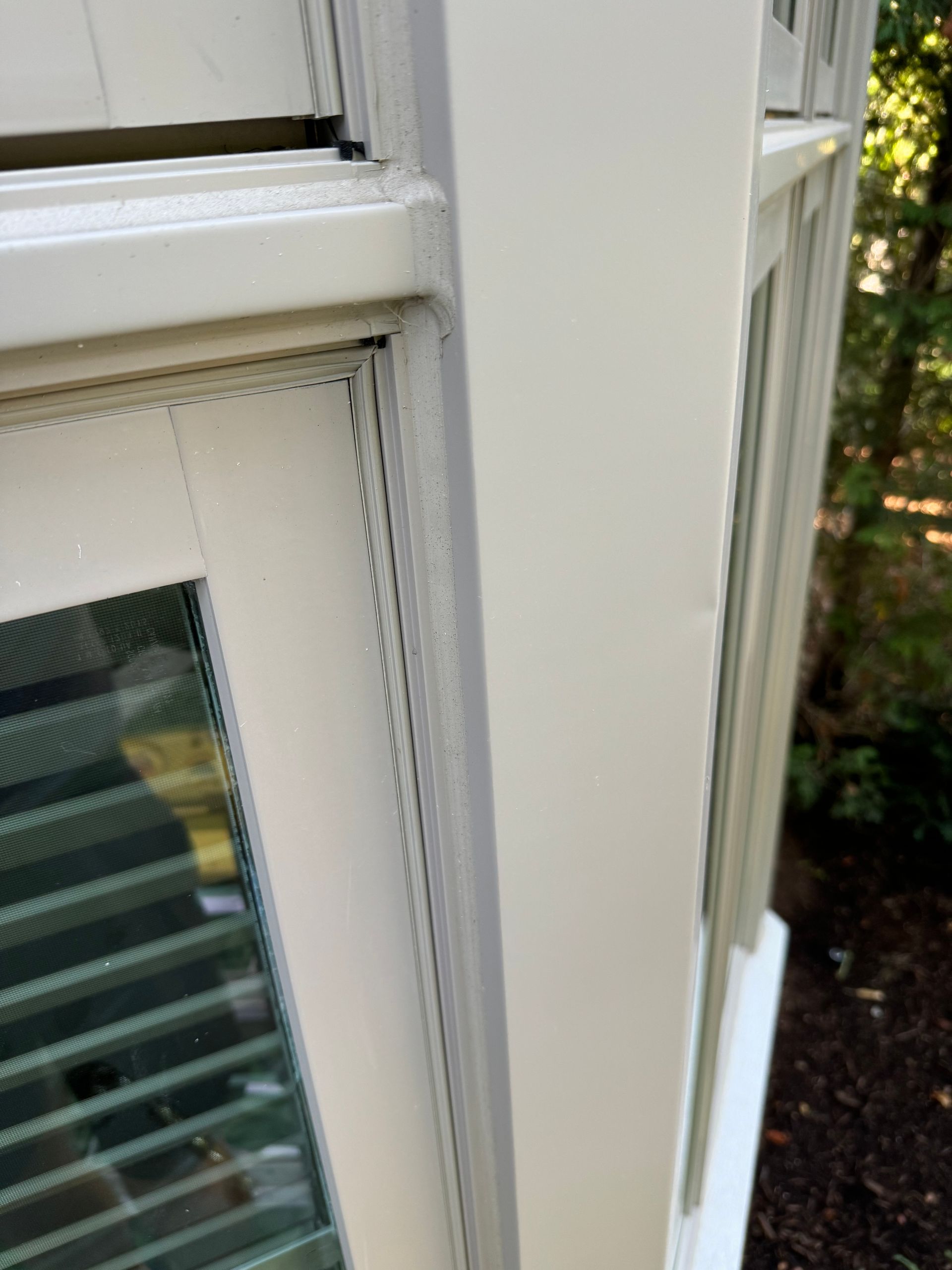 A close up of a white window on a house.
