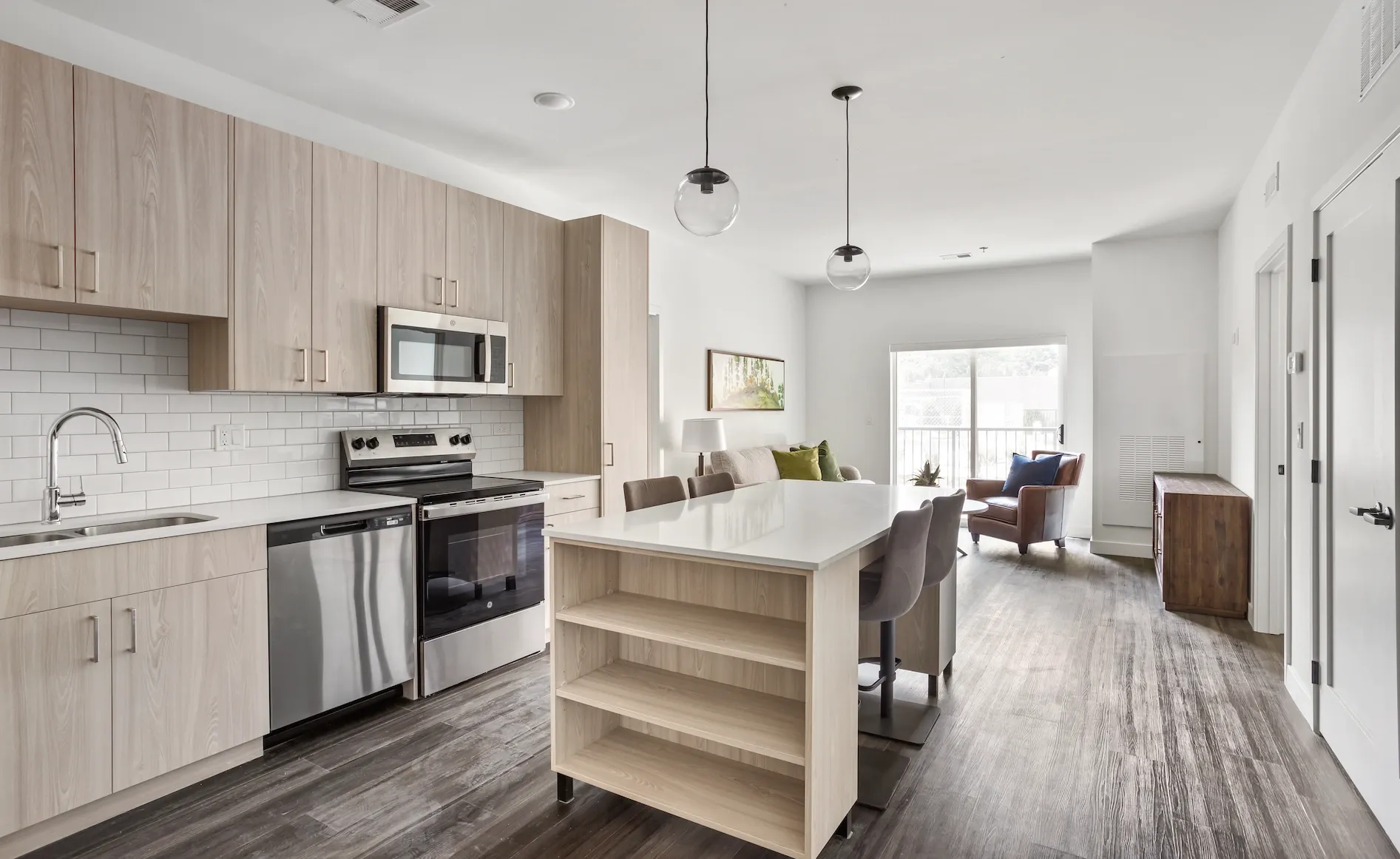 Modern kitchen with island and open living area at Station 250 in Mundelein, IL.