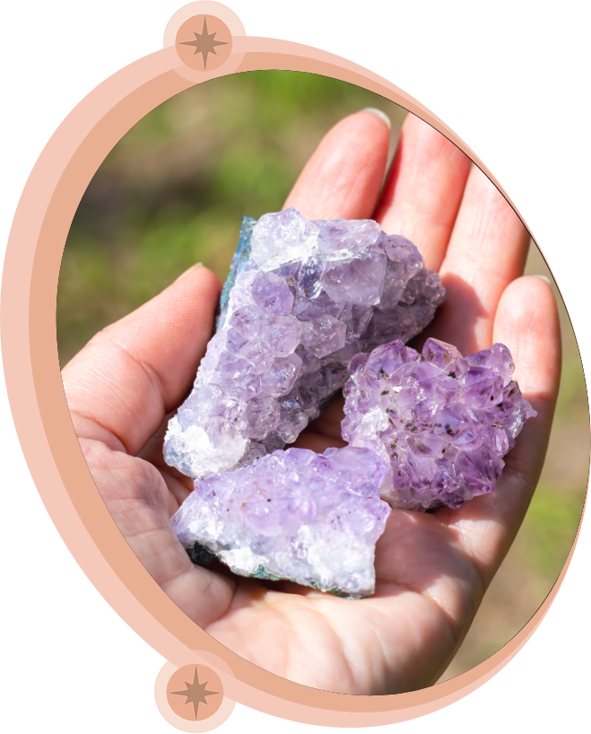 Hand holding three amethyst crystals, light purple hue.