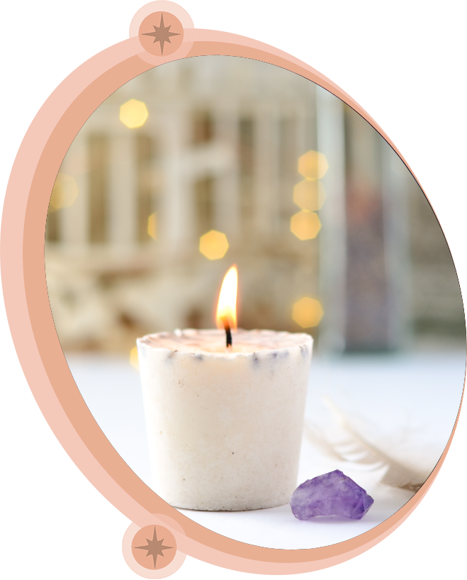 Lit candle in a white holder with amethyst crystal, soft background with bokeh lights.