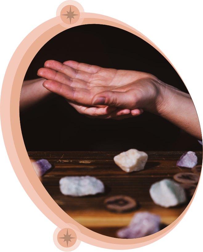 Hands over a table with crystals. Dark background, warm lighting.