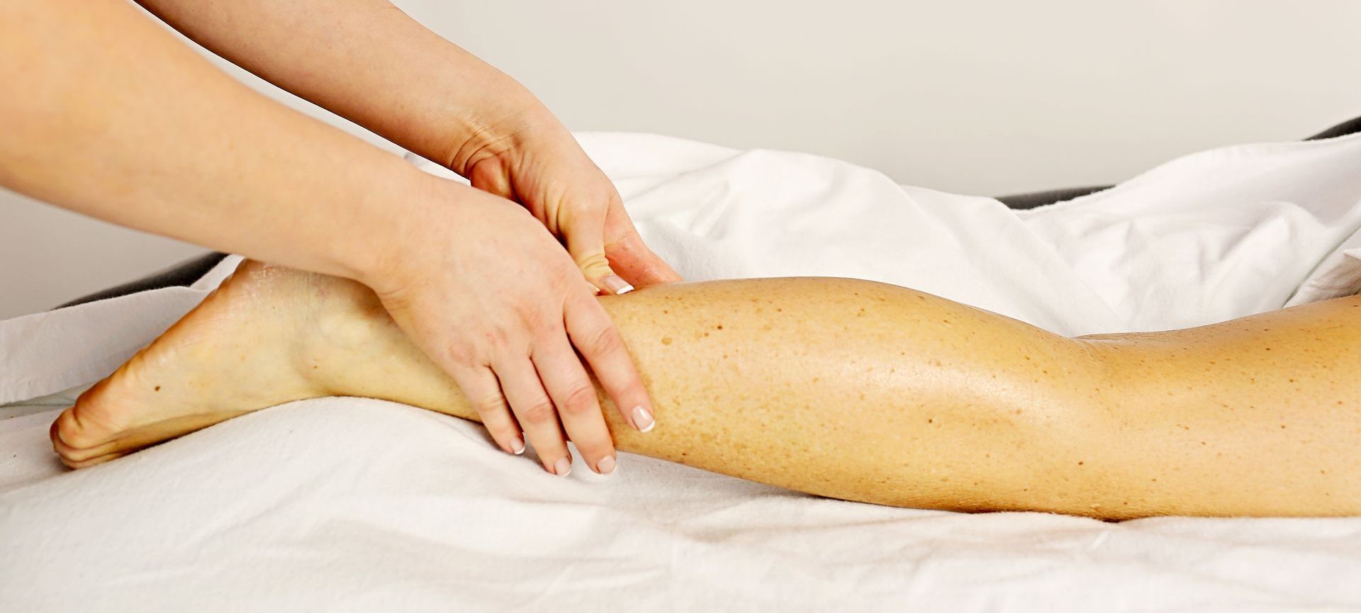 a woman is getting a massage on her leg at A Touch of Recovery in Plymouth, MI