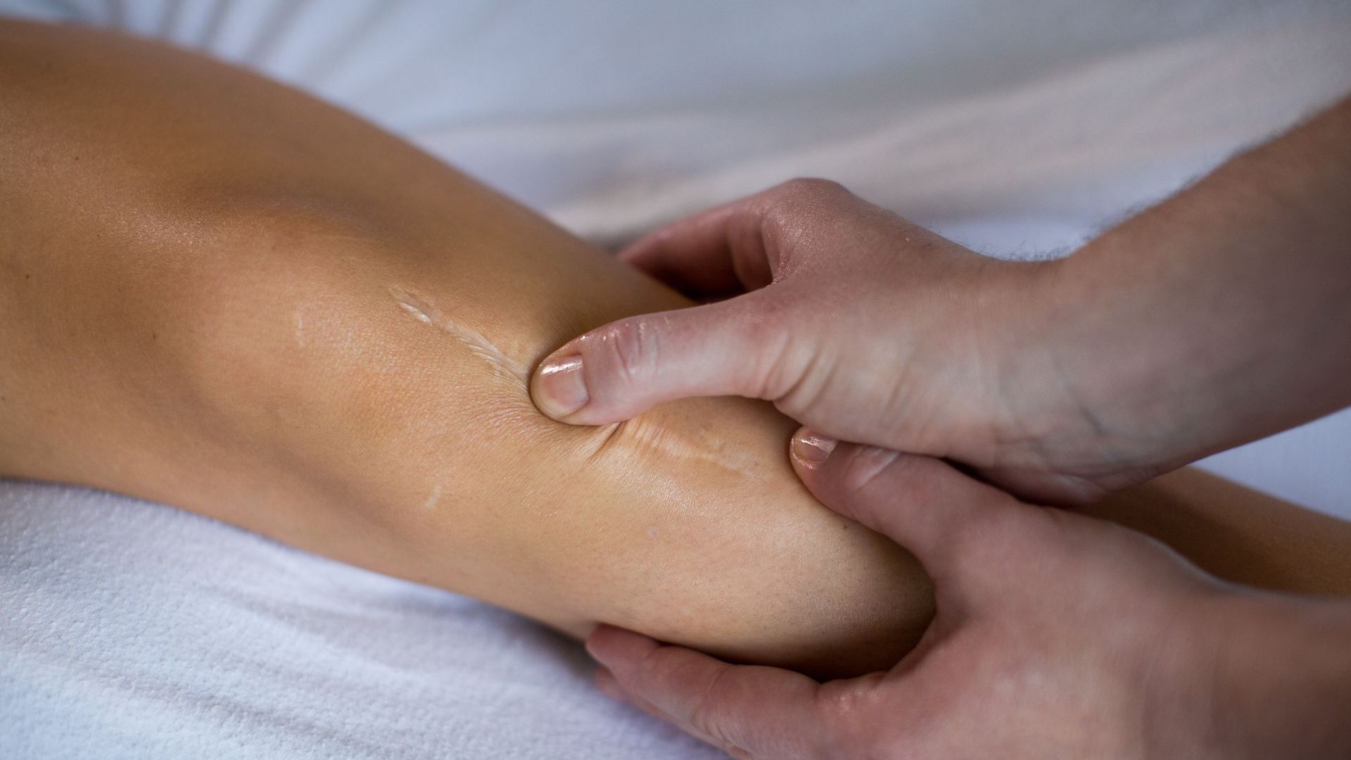 an athlete gets specialized massage for faster recovery on their knee area