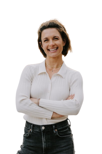 A woman is standing with her arms crossed and smiling.