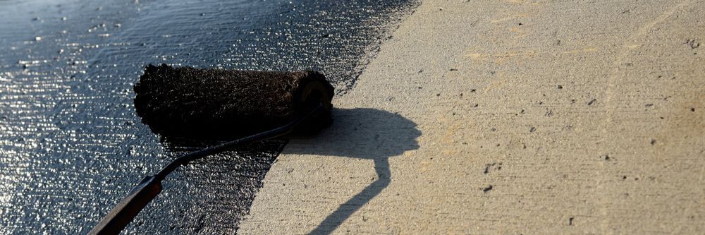 A Roller is Being Used to Paint a Concrete Surface — Legend Waterproofing In Nords Wharf, NSW