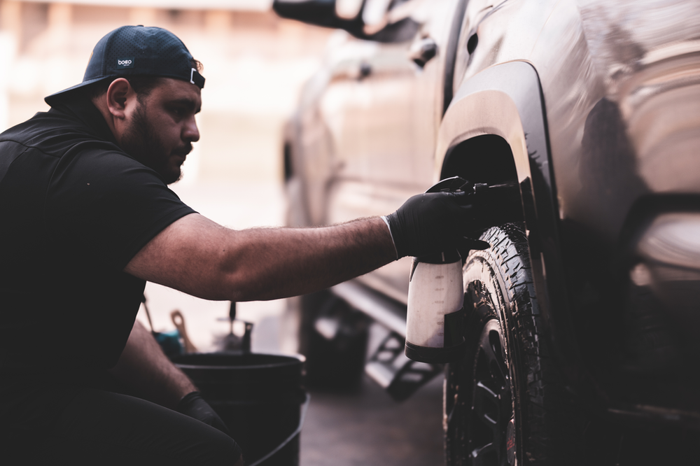 A man is working on a car in a garage.