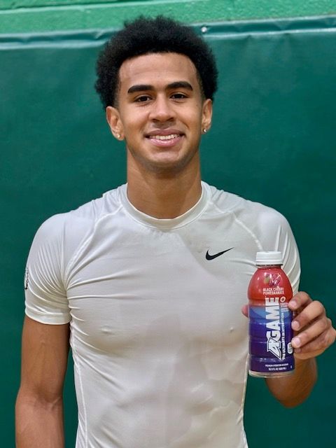 A man in a white nike shirt is holding a bottle of gatorade