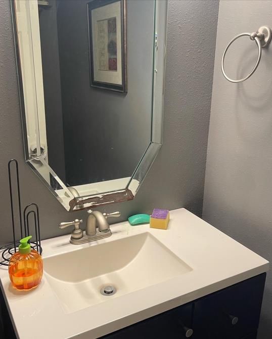 A bathroom with a sink and a mirror