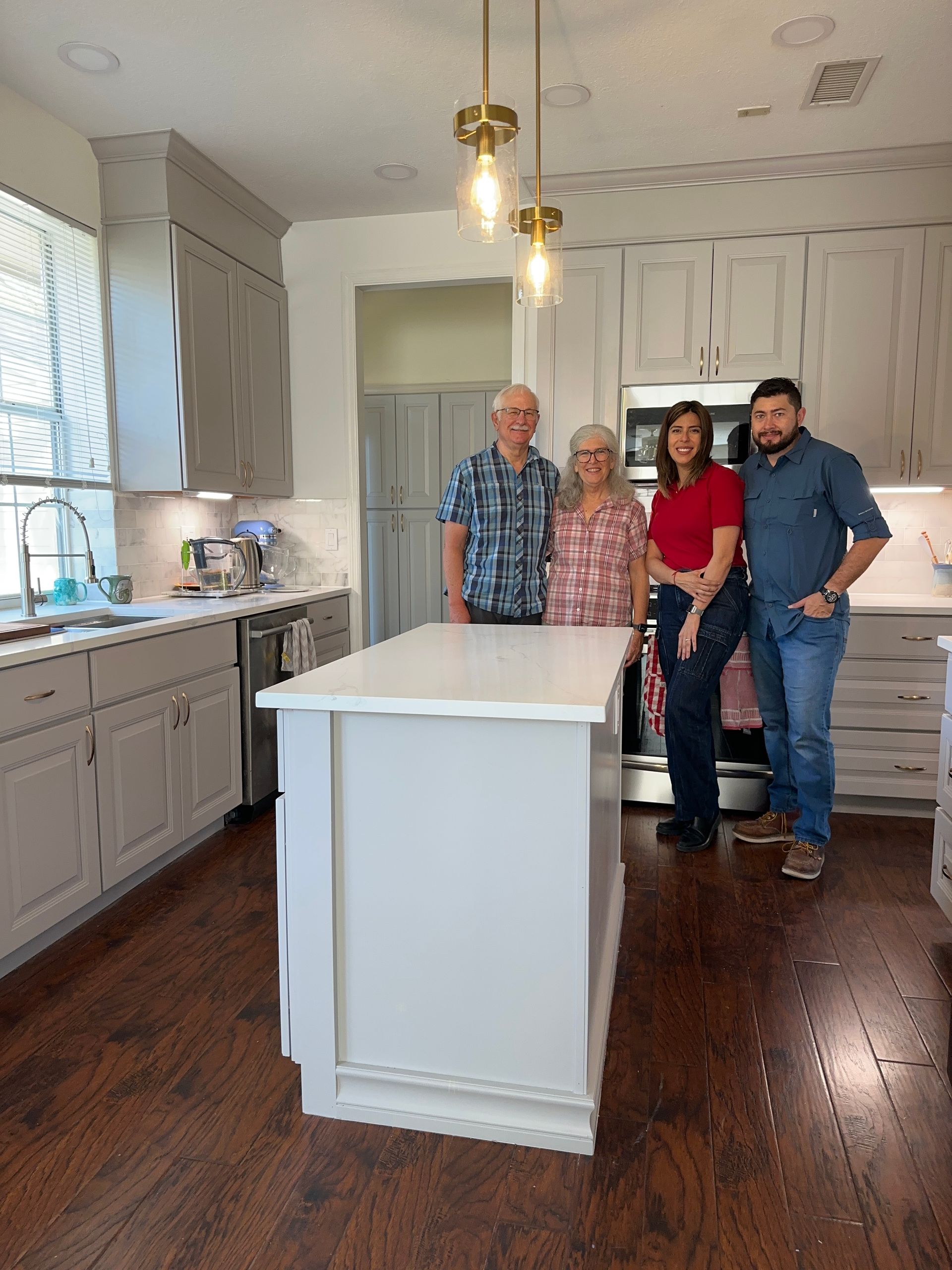 A family is posing for a picture in a kitchen.