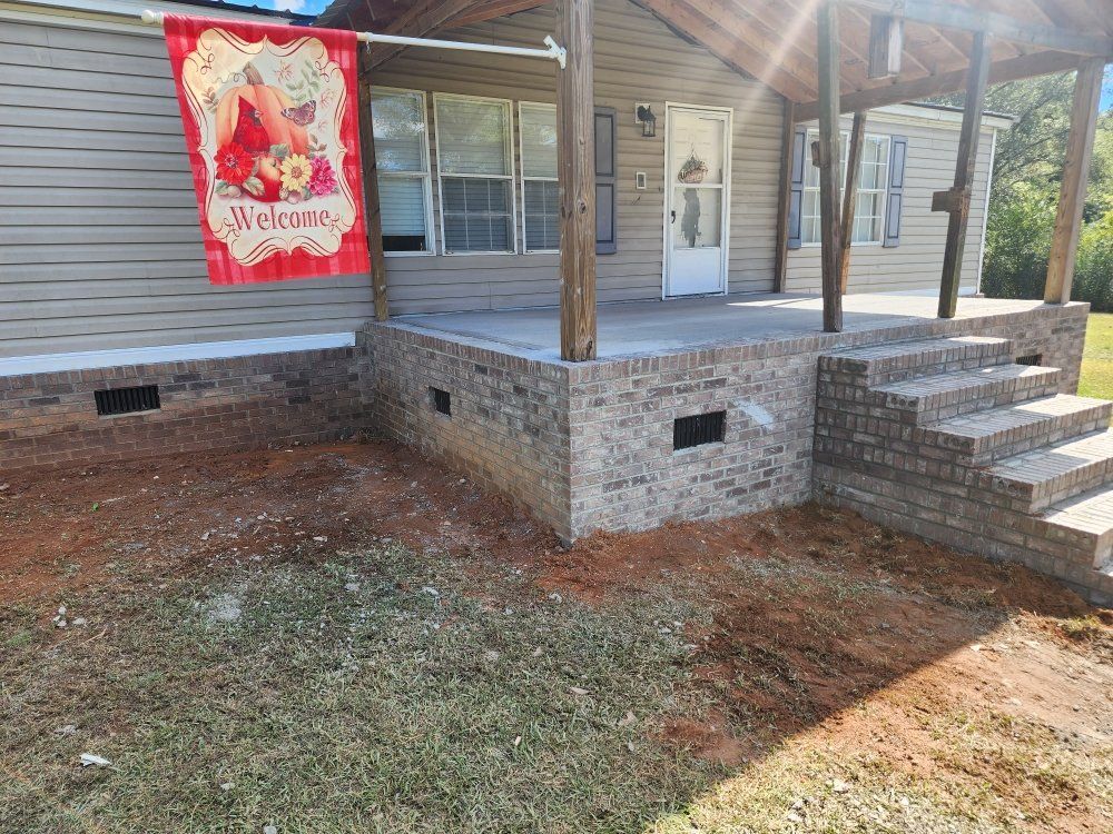 Front porch with stone steps, wooden posts, and a red holiday banner on a house exterior