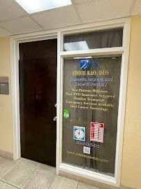 Exterior of Eddie Kao, DDS dental office. Brown door, window with business information, beige walls.