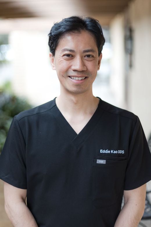 Team at Eddie Kao DDS dental office behind reception desk.