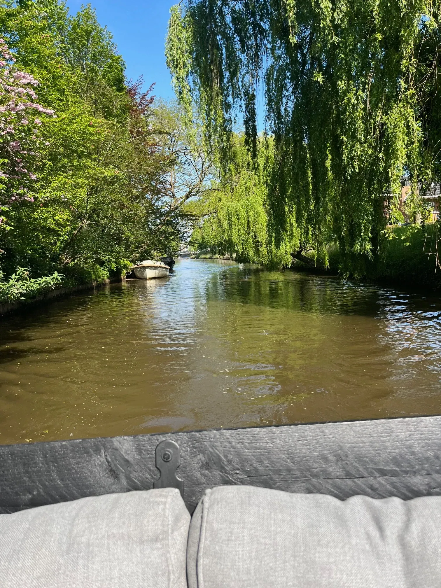 Een boot drijft op de Mark in Breda, omgeven door bomen.