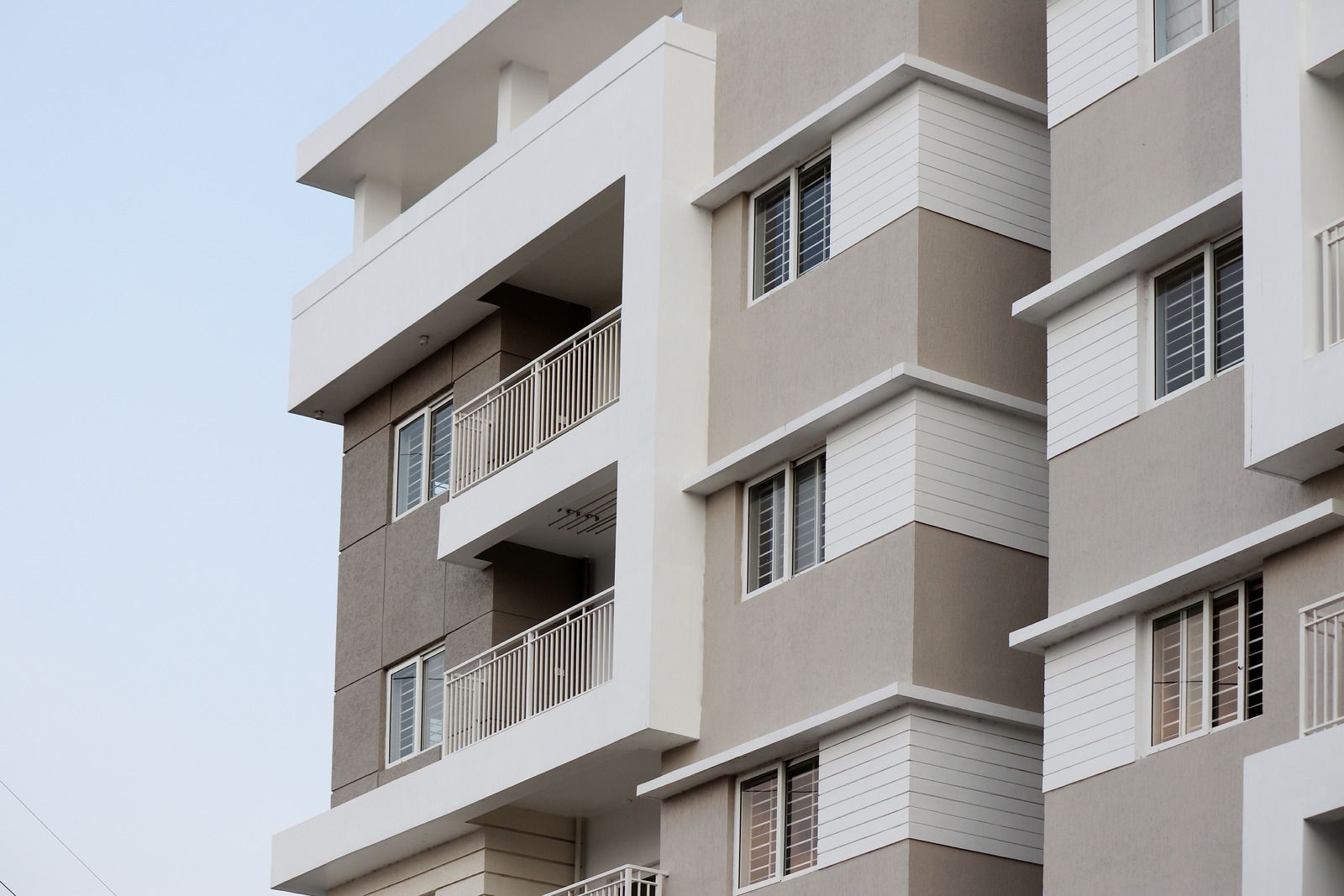 Modern apartment building facade with balconies and gray-white exterior