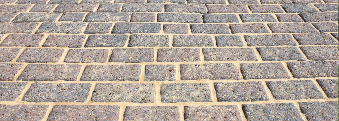 A close up of a brick pavement with a diagonal pattern.
