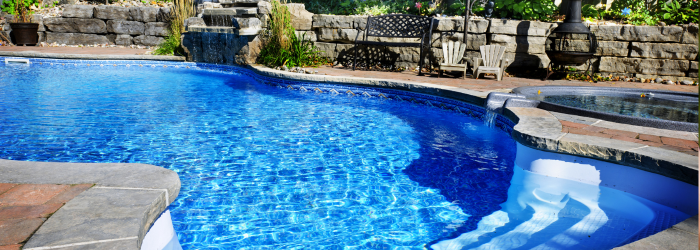A large swimming pool with a waterfall in the background.