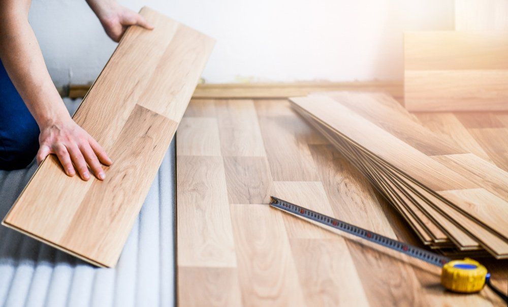 Man Installing Timber Flooring — Furnishers in Alice Springs, NT