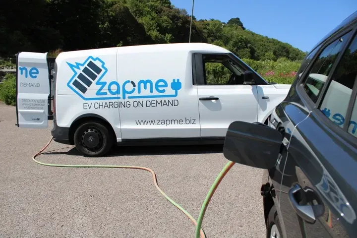 a ZAPME van is charging a black car