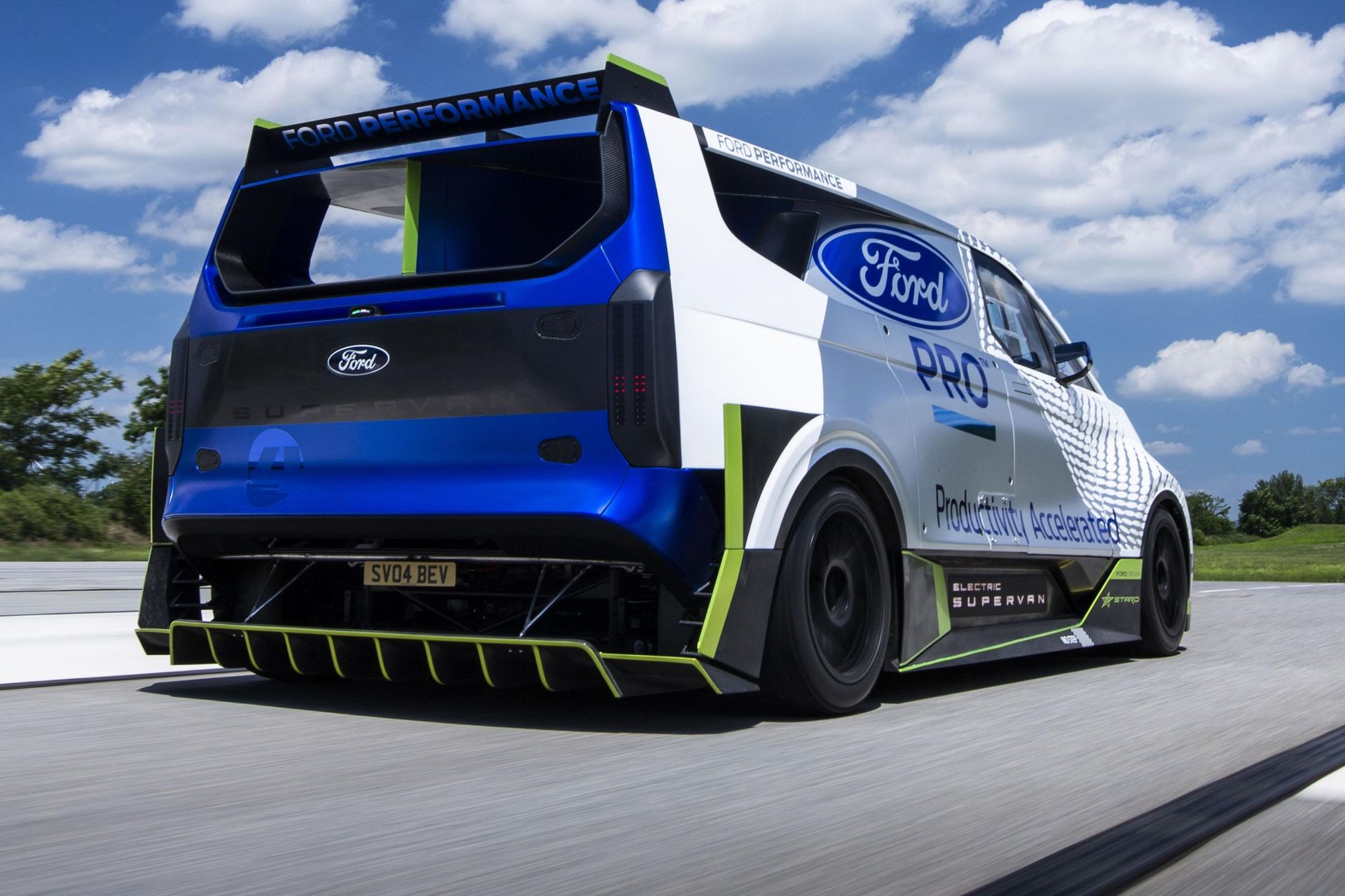 a blue and white electric vehicle ford supervan is driving down a road