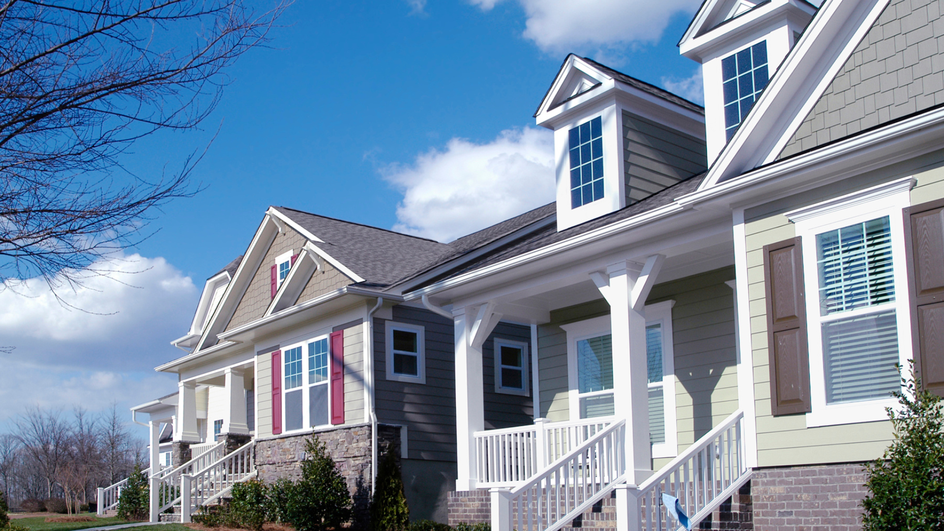A row of houses with porches and stairs on a sunny day.