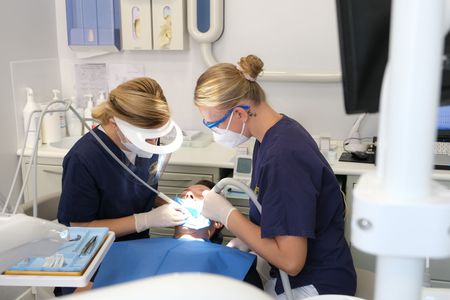 Poltrona odontoiatrica blu e attrezzature in una stanza clinica pulita.