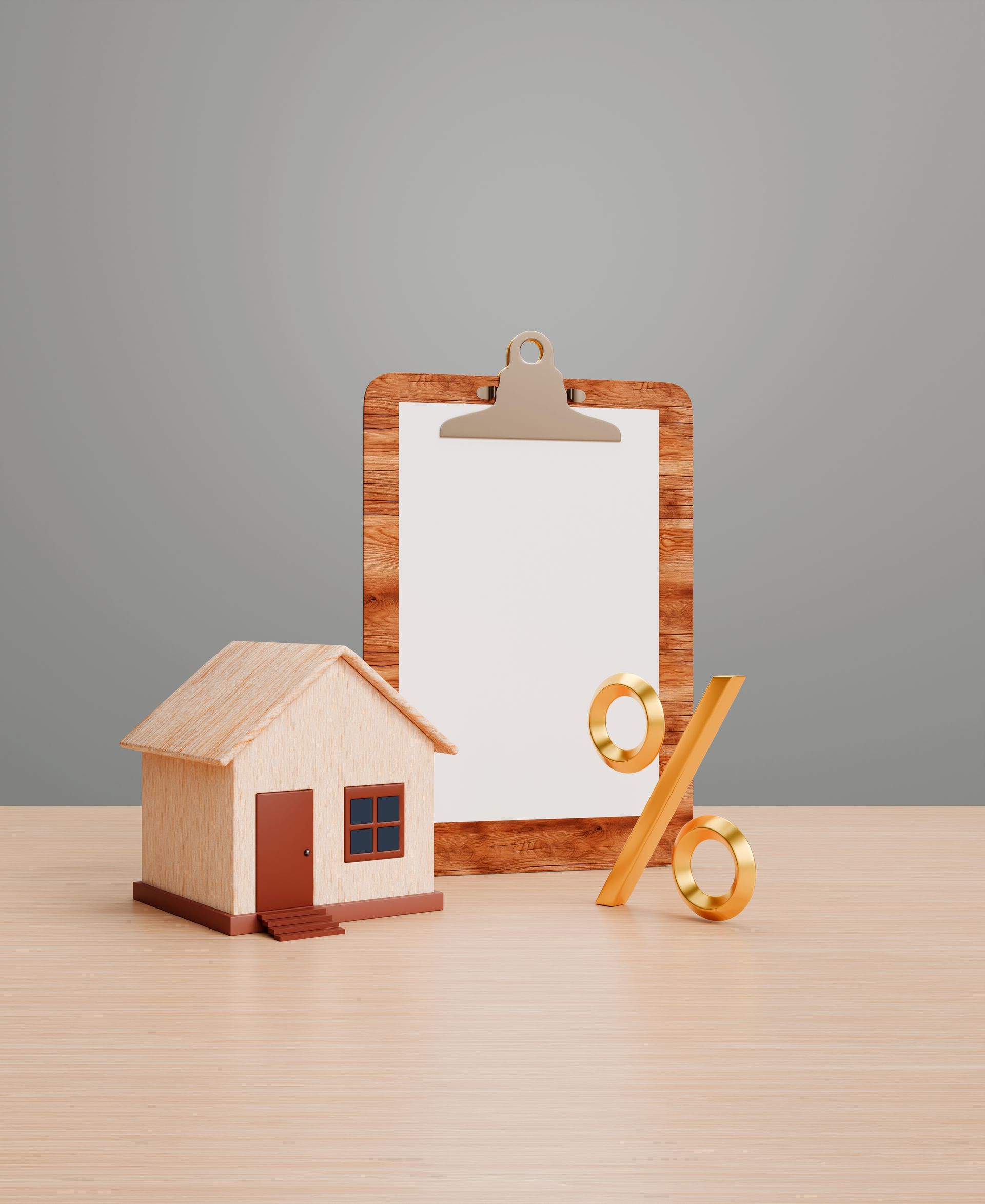 Small cardboard house, clipboard, and pencil on a tabletop, suggesting home budgeting or planning