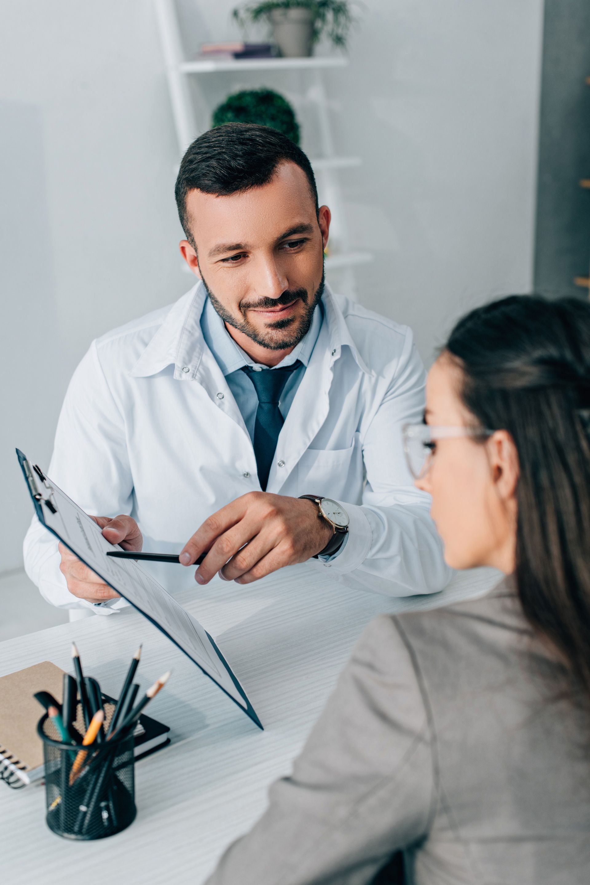 Doctor discussing paperwork with a patient in a bright clinic office