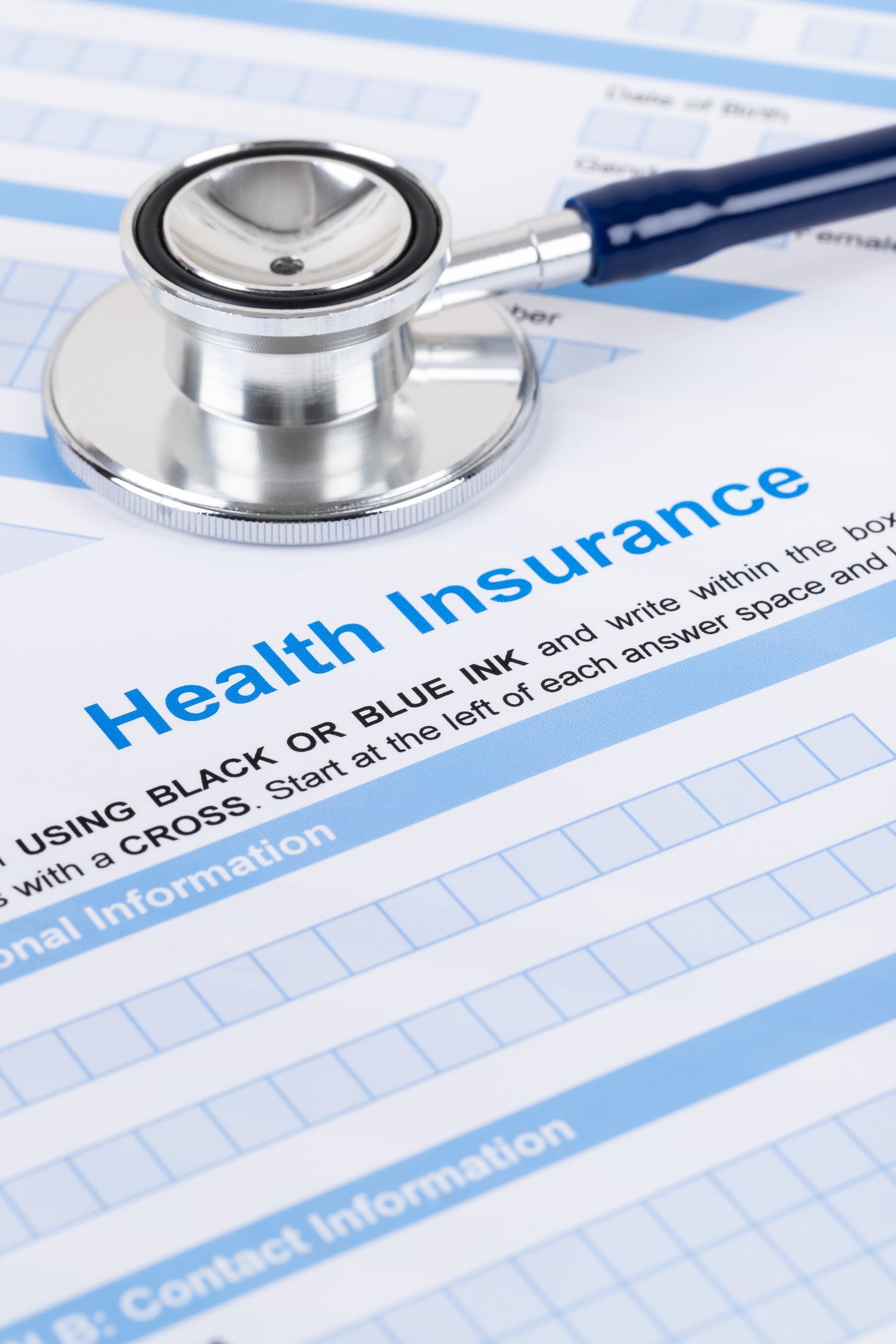 Stethoscope on a blue health insurance form with visible “Health Insurance” heading