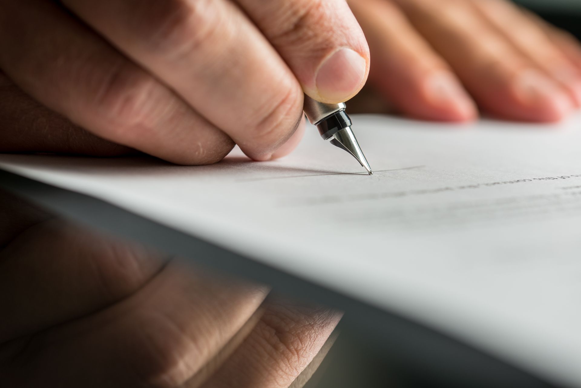 Hand writing with a fountain pen on a blank sheet of paper, close-up.