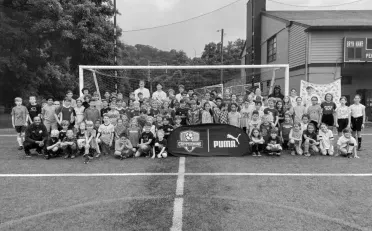a group of children are posing for a picture on a soccer field .
